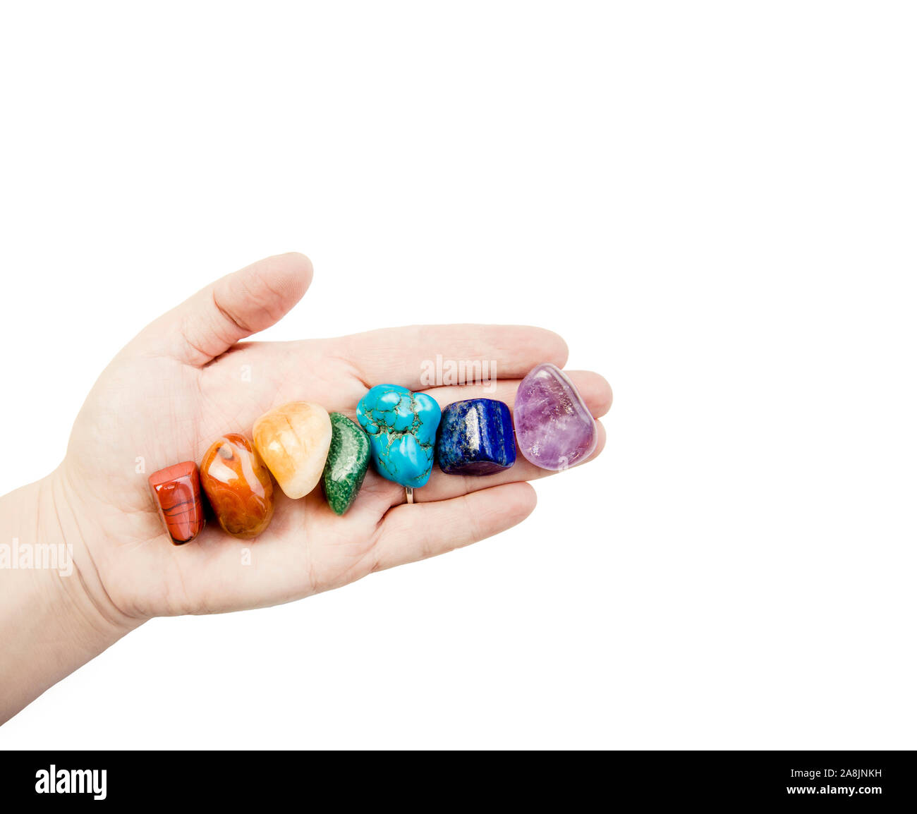 Vista ravvicinata della donna guaritore mano che mostra tutti i sette chakra colore pietre di cristallo in ordine di colore, isolato su sfondo bianco. Crystal healer lifestyl Foto Stock