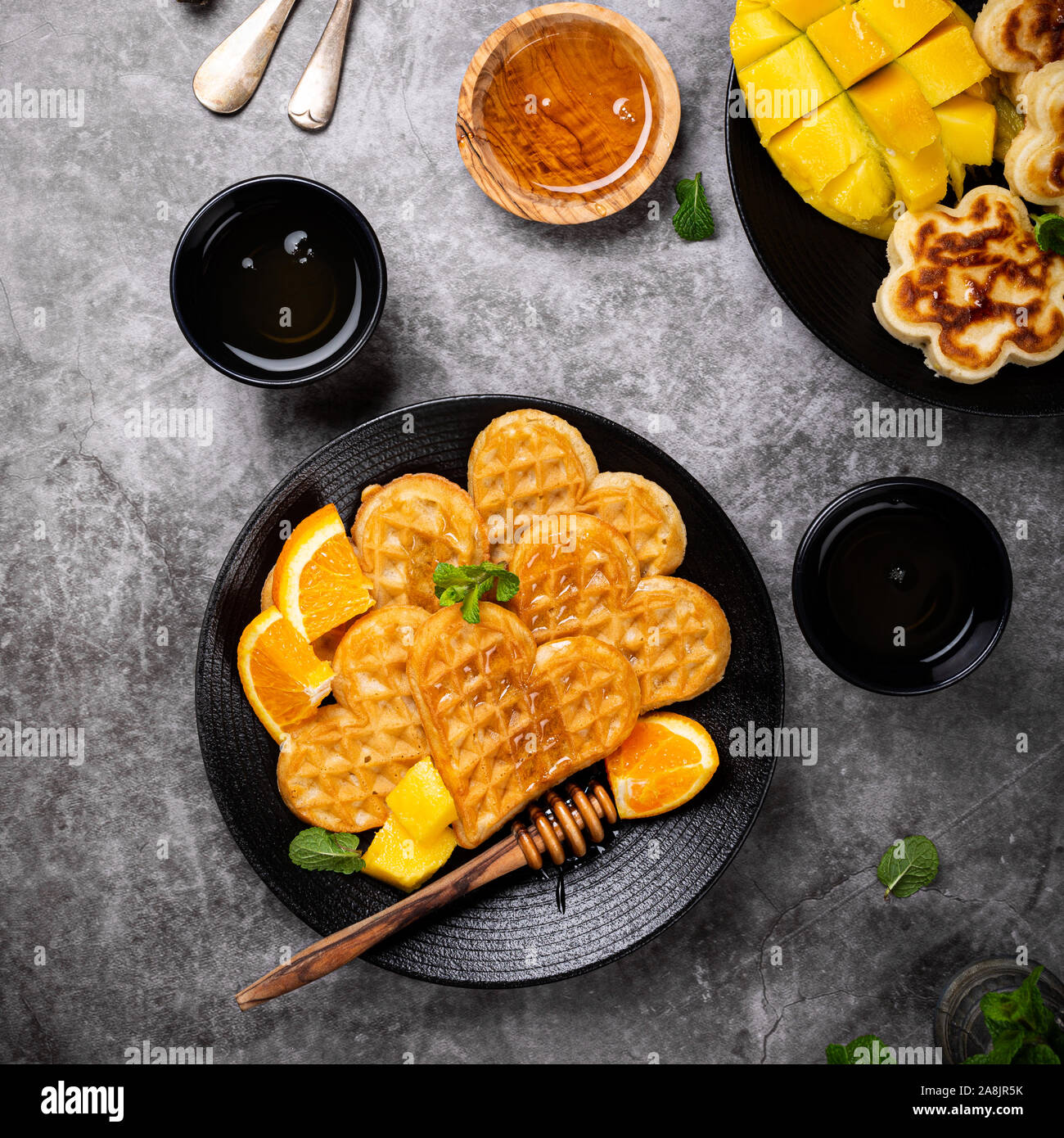 Sana colazione con prodotti freschi cialde calde cuori, frittelle di fiori Foto Stock