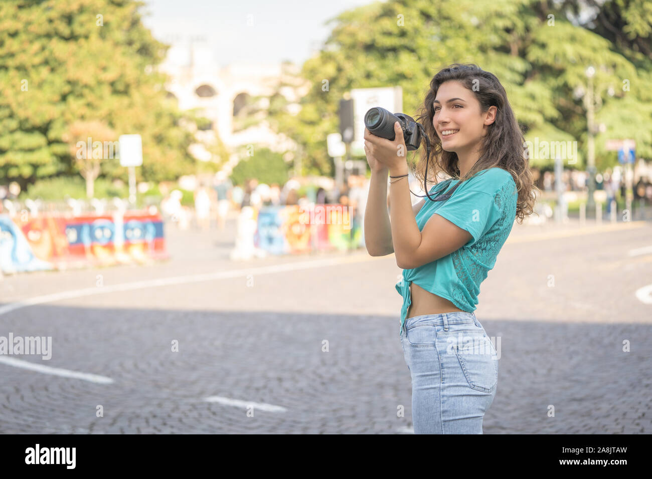 Ragazza sorridente in una città italiana con una macchina fotografica in mano. Foto Stock