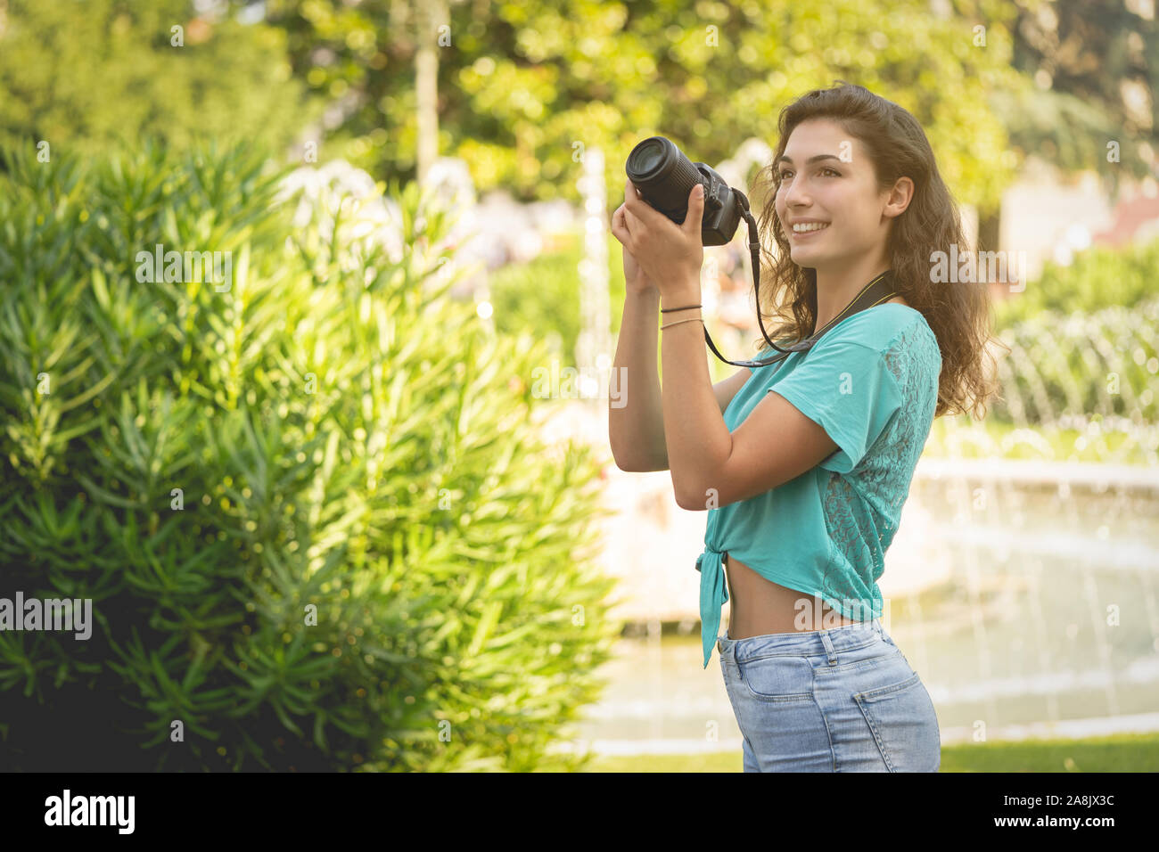 Ragazza sorridente in una città italiana con una macchina fotografica in mano. Foto Stock