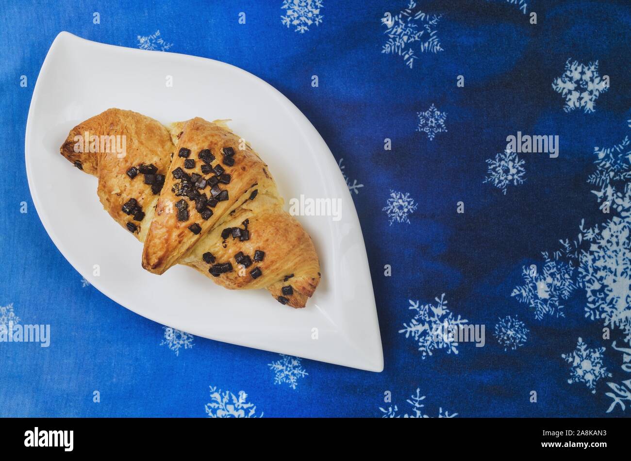 Delizioso dolce pasto. Golden croissant su un blu sfondo d'inverno. Foto Stock