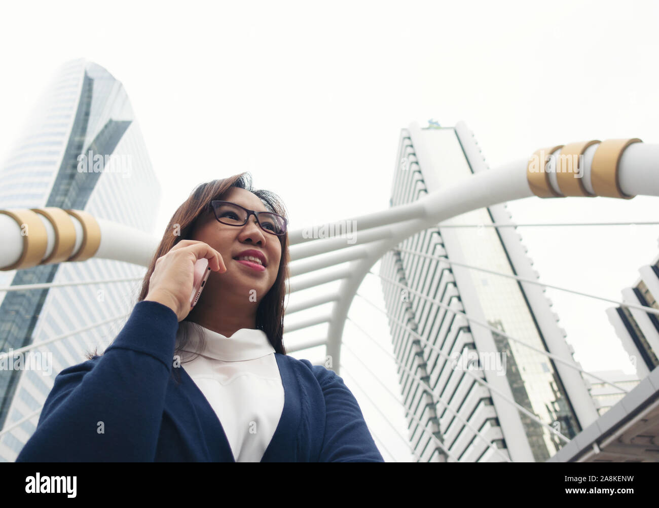 Imprenditrice passeggiate all'aperto e parlando al telefono cellulare Foto Stock