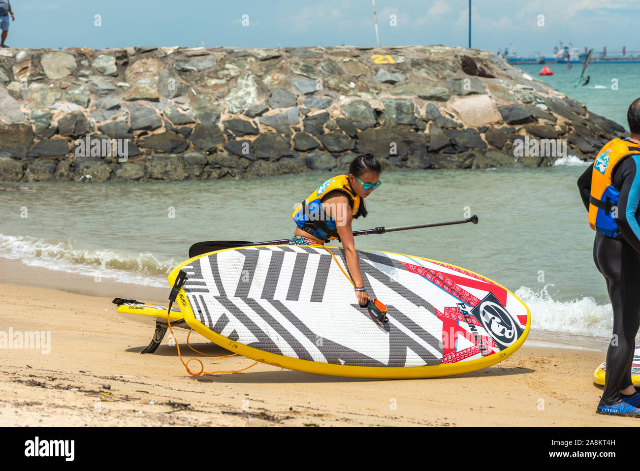 Gli uomini e le donne windsurfisti svolgere commissioni dopo la navigazione Foto Stock