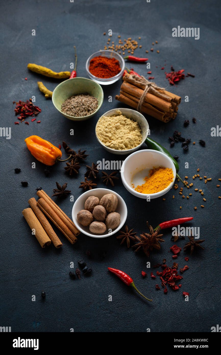 Cibo scuro dello sfondo con spice in ciotole Foto Stock