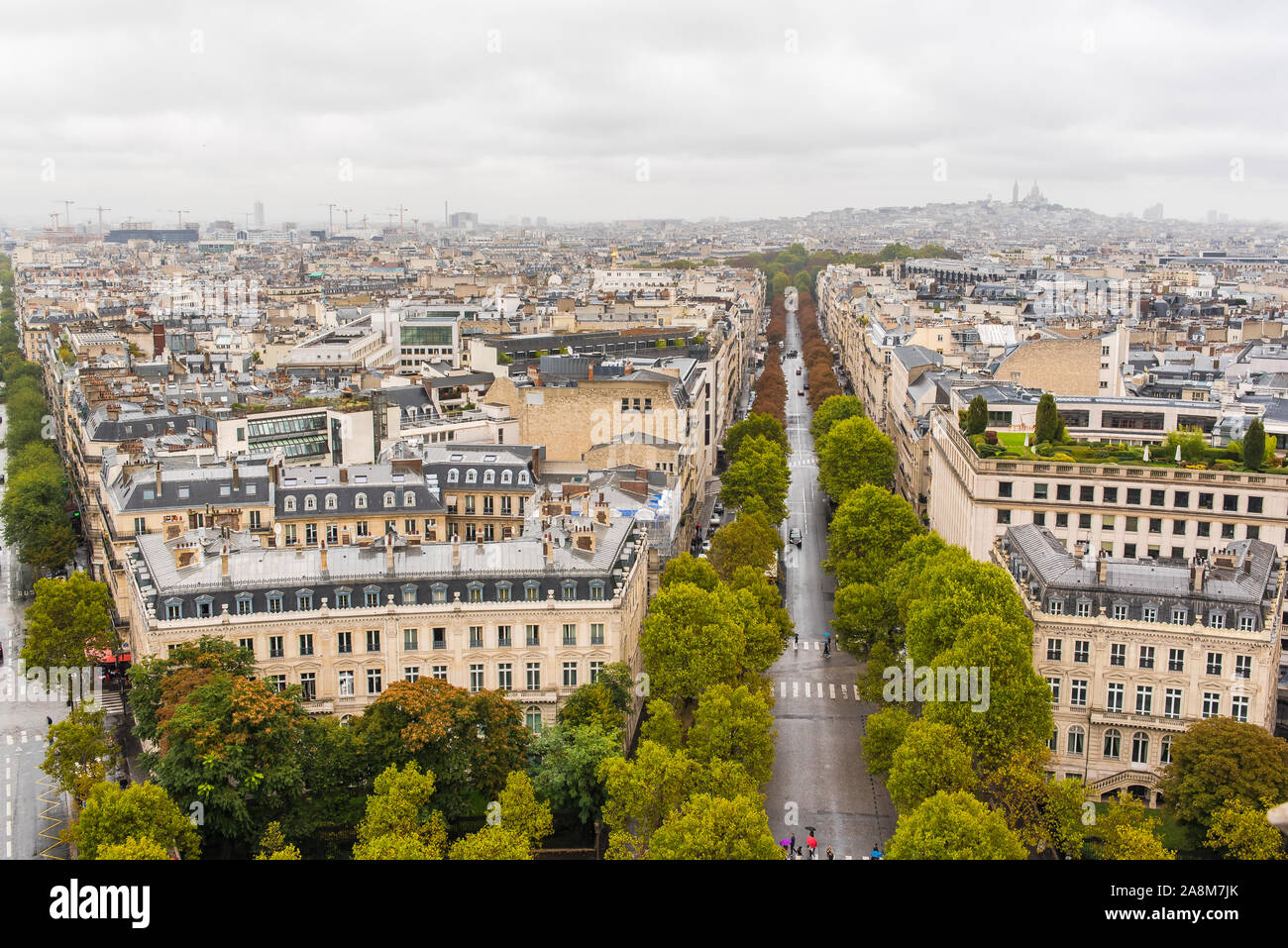 Parigi, panorama dall'Arco di Trionfo in una giornata piovosa, edifici, viali e monumenti, e il Sacre-Choeur e Montmartre in background Foto Stock