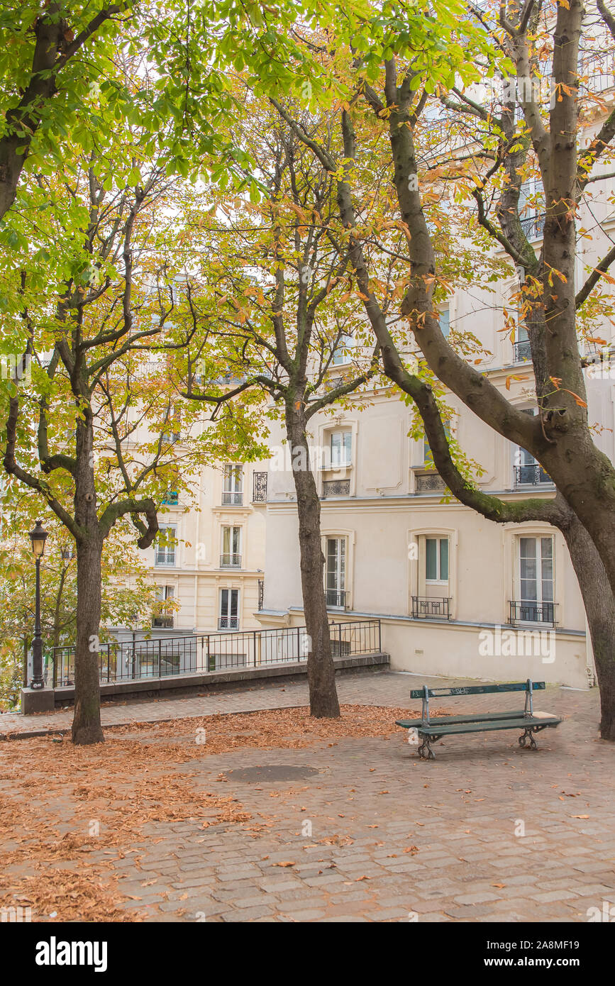 Parigi, luogo romantico a Montmartre in autunno, con foglie morte e una tipica panchina Foto Stock