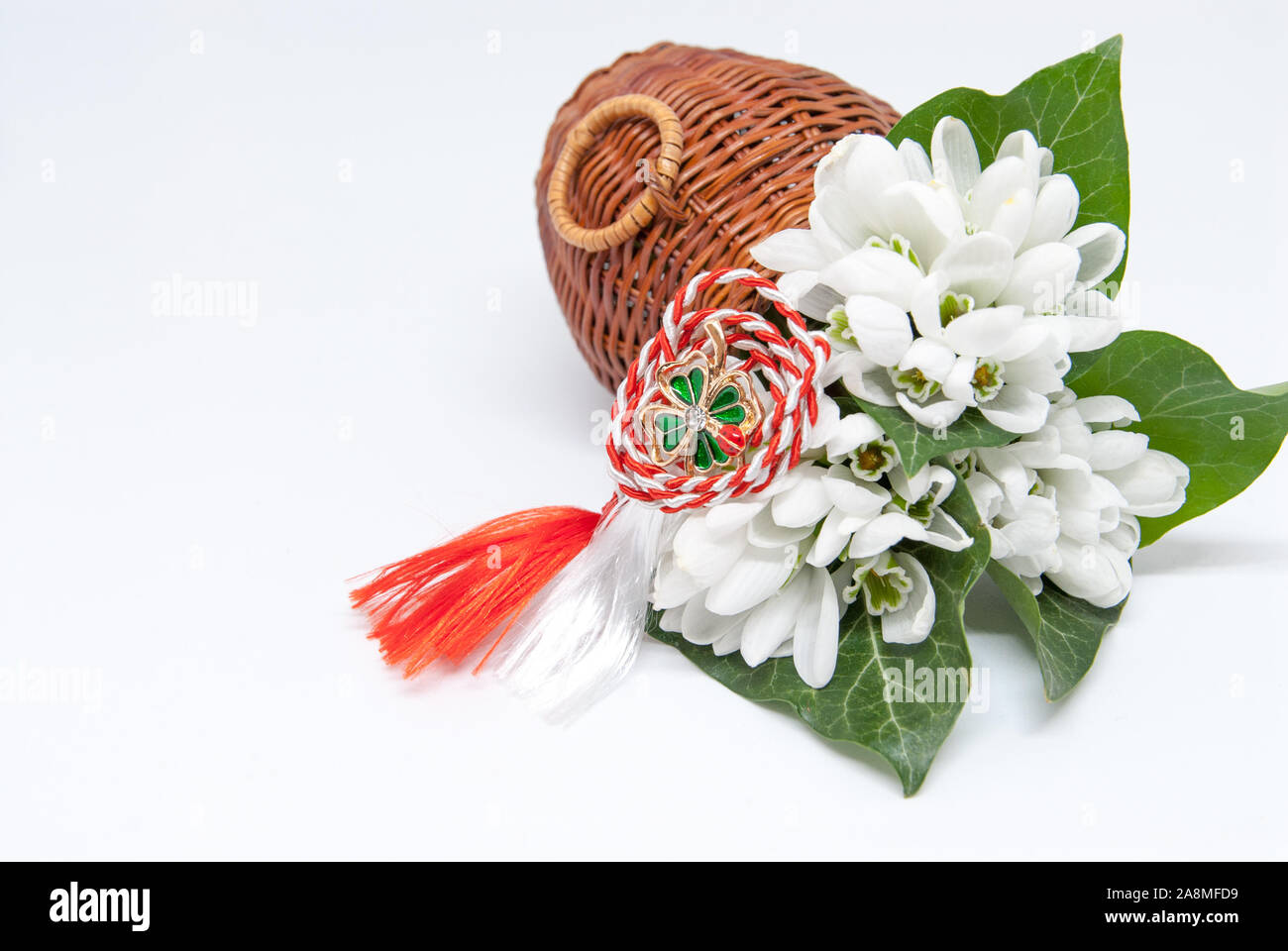 Snowdrops e rosso e bianco martisor stringa su bianco con spazio copia dell est europeo prima di marzo Celebrazione della tradizione Foto Stock