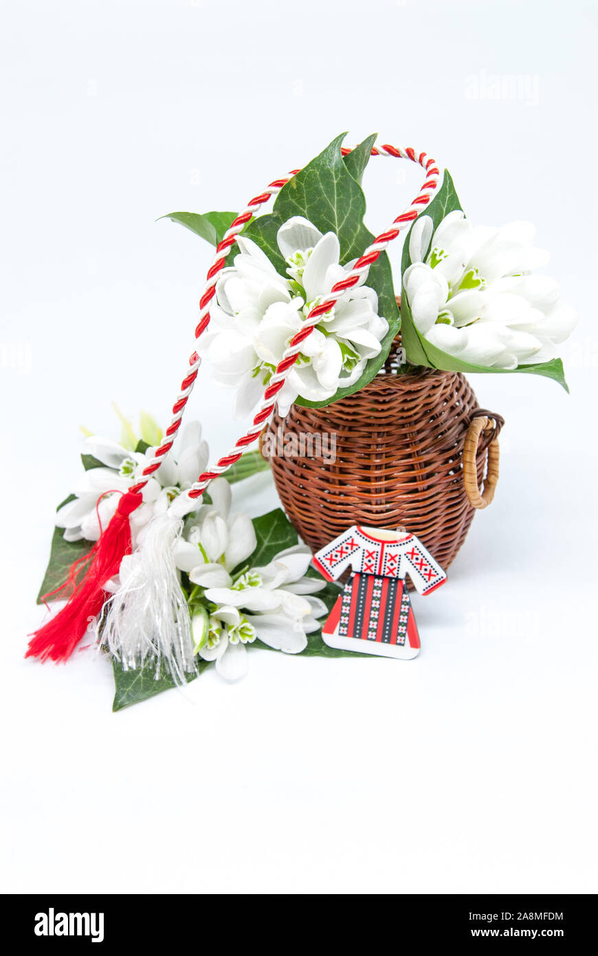 Snowdrops e rosso e bianco martisor stringa su bianco con spazio copia dell est europeo prima di marzo Celebrazione della tradizione Foto Stock