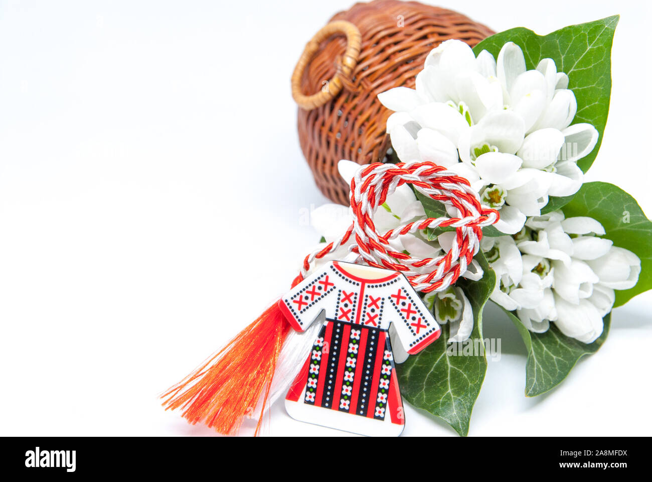 Snowdrops e rosso e bianco martisor stringa su bianco con spazio copia dell est europeo prima di marzo Celebrazione della tradizione Foto Stock