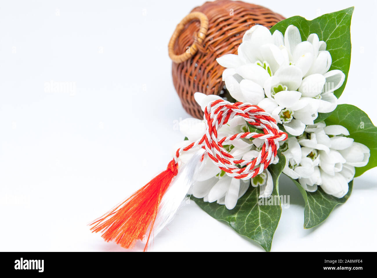 Snowdrops e rosso e bianco martisor stringa su bianco con spazio copia dell est europeo prima di marzo Celebrazione della tradizione Foto Stock