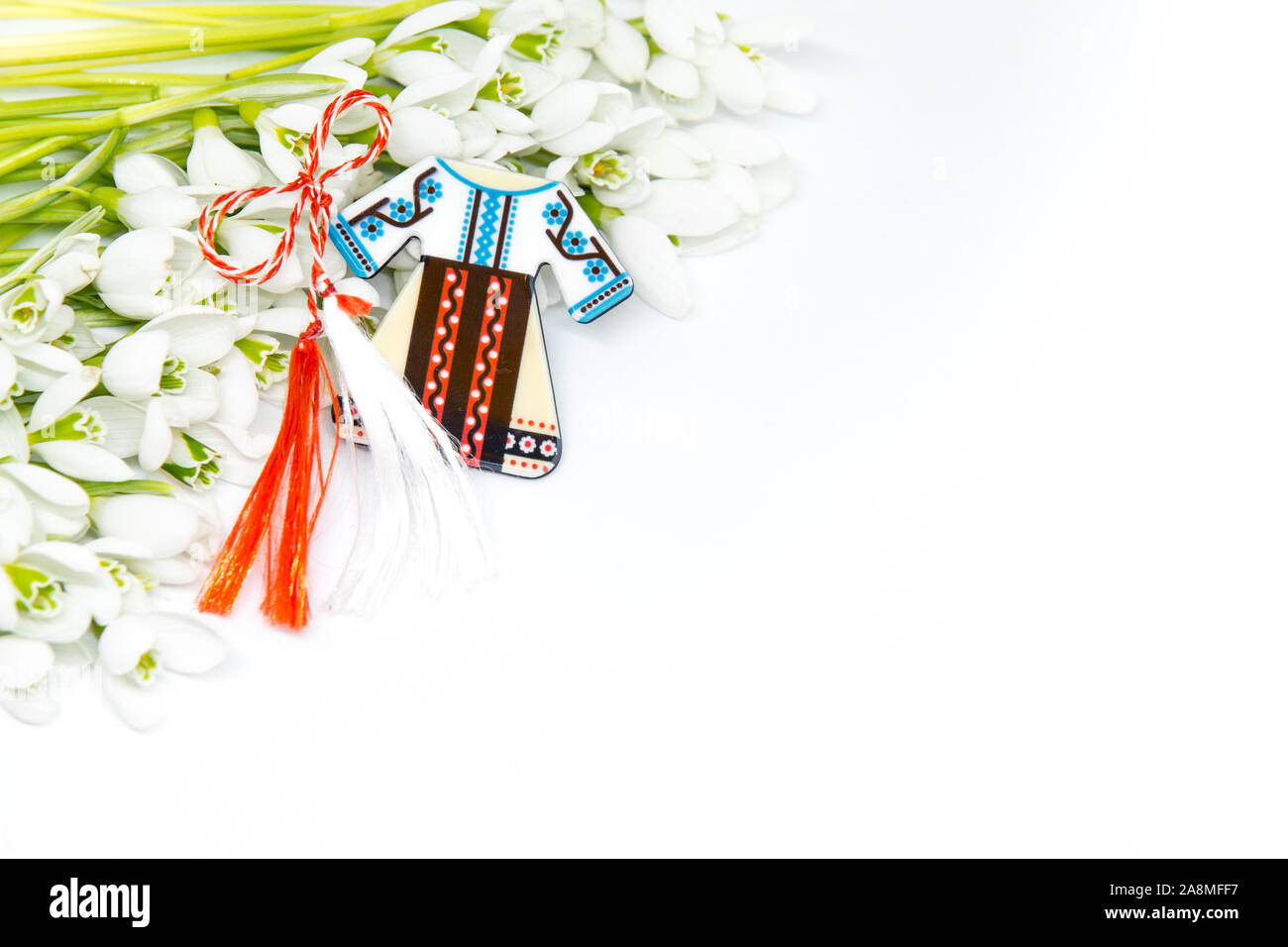 Snowdrops e rosso e bianco martisor stringa su bianco con spazio copia dell est europeo prima di marzo Celebrazione della tradizione Foto Stock