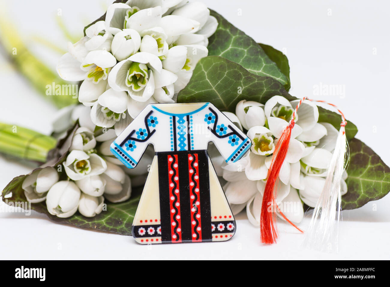 Snowdrops e rosso e bianco martisor stringa su bianco con spazio copia dell est europeo prima di marzo Celebrazione della tradizione Foto Stock