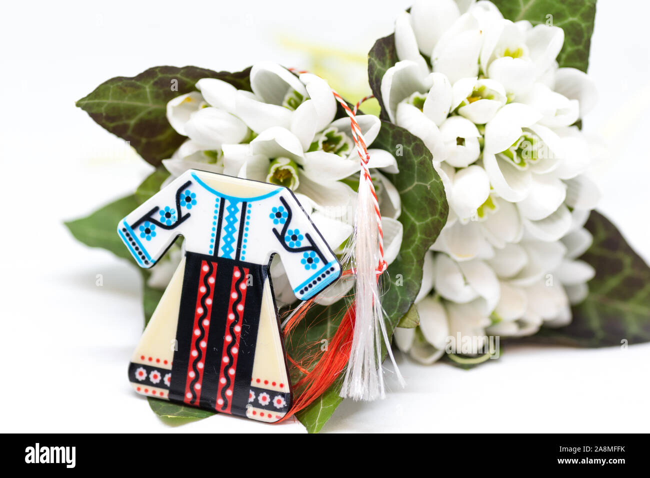 Snowdrops e rosso e bianco martisor stringa su bianco con spazio copia dell est europeo prima di marzo Celebrazione della tradizione Foto Stock