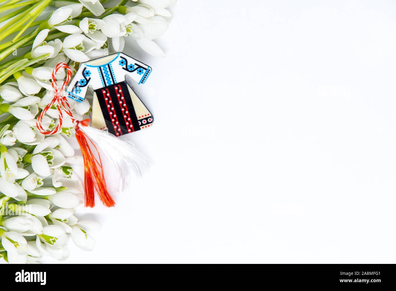 Snowdrops e rosso e bianco martisor stringa su bianco con spazio copia dell est europeo prima di marzo Celebrazione della tradizione Foto Stock