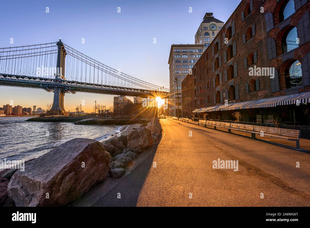 Manhattan Bridge in controluce, sole di mattina, Sun Star, Sunrise, Empire Fulton Ferry Park, Dumbo, Brooklyn, New York, Stati Uniti d'America Foto Stock