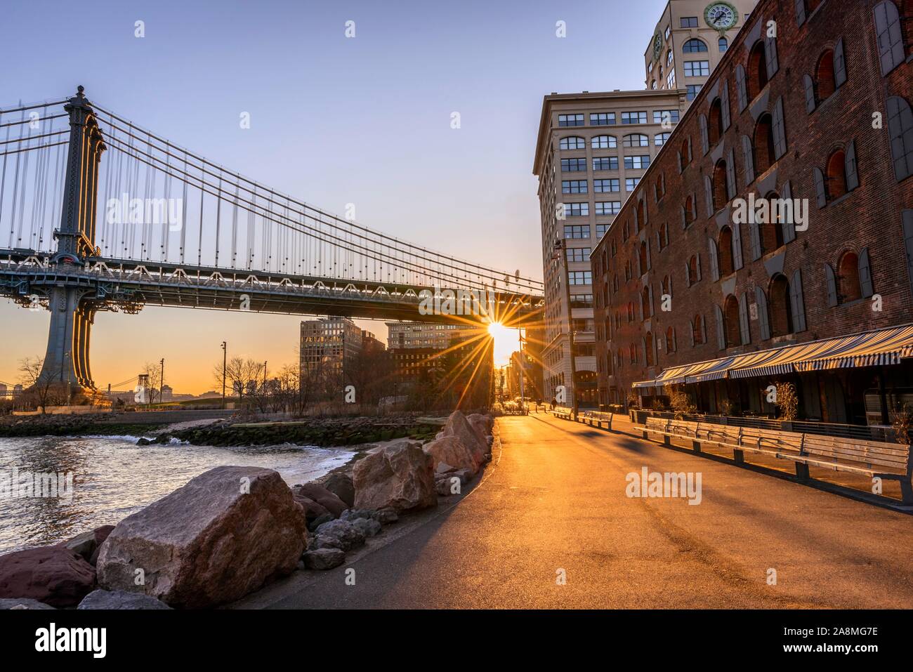 Manhattan Bridge in controluce, sole di mattina, Sun Star, Sunrise, Empire Fulton Ferry Park, Dumbo, Brooklyn, New York, Stati Uniti d'America Foto Stock