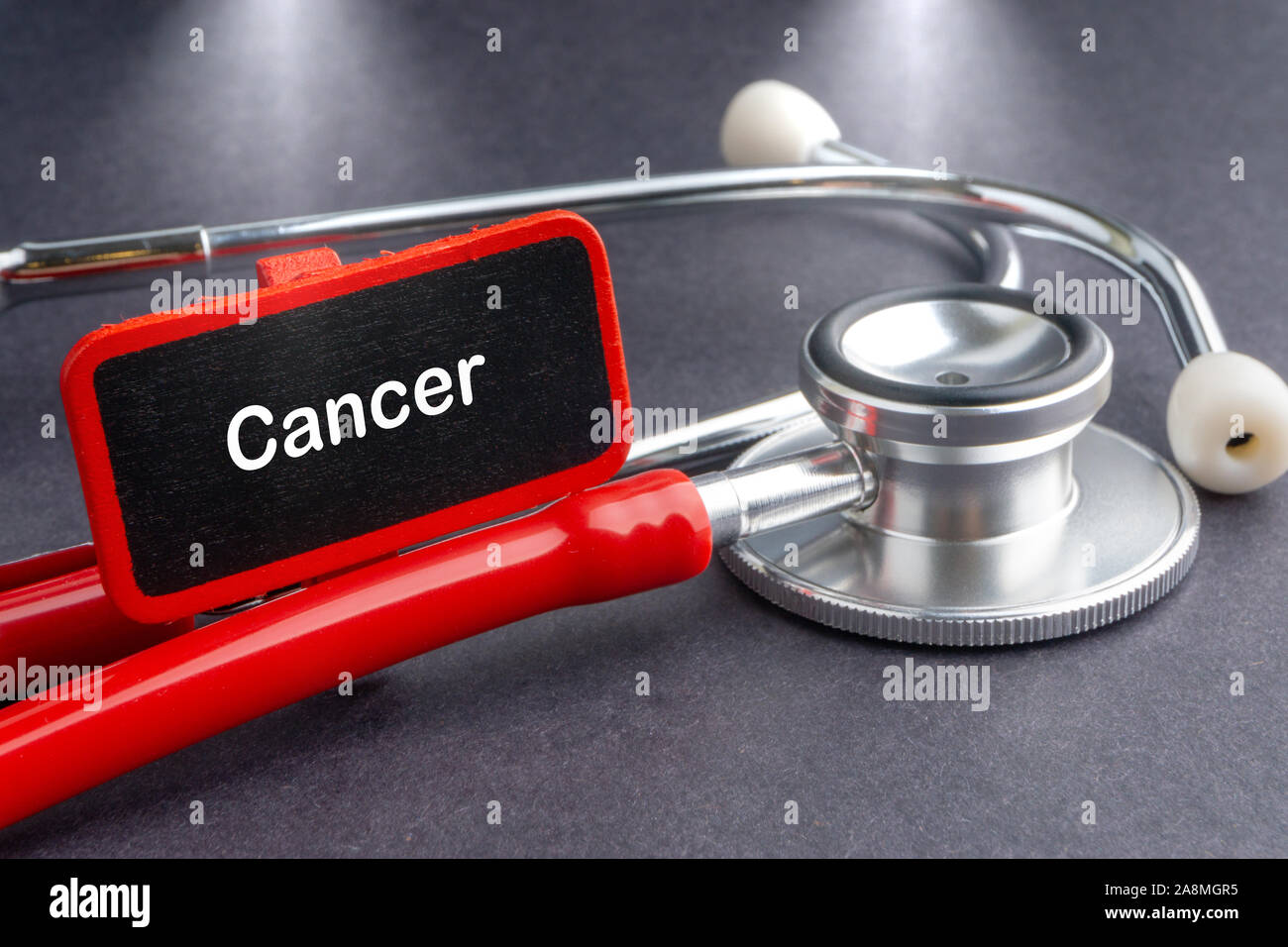 Il cancro. Il concetto di medicina. Lavagna con word il cancro e lo stetoscopio Foto Stock