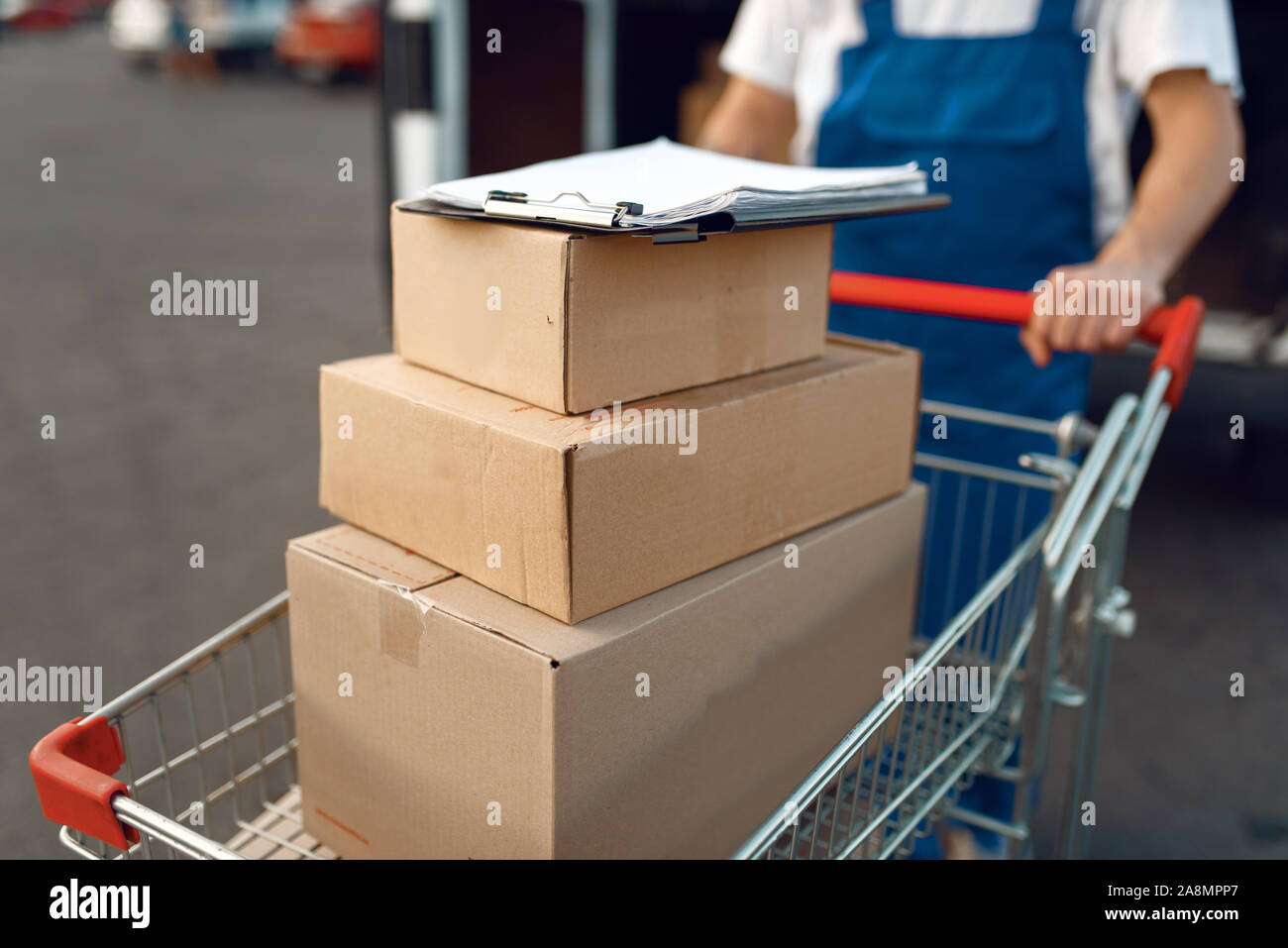 Deliveryman detiene il carrello con la pila di scatole Foto Stock