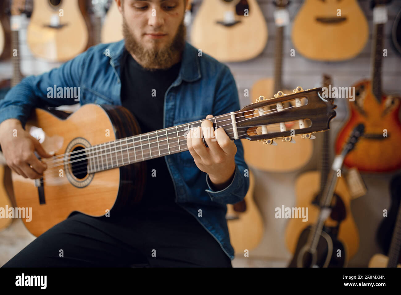 Il chitarrista suona sulla chitarra acustica in music store Foto Stock