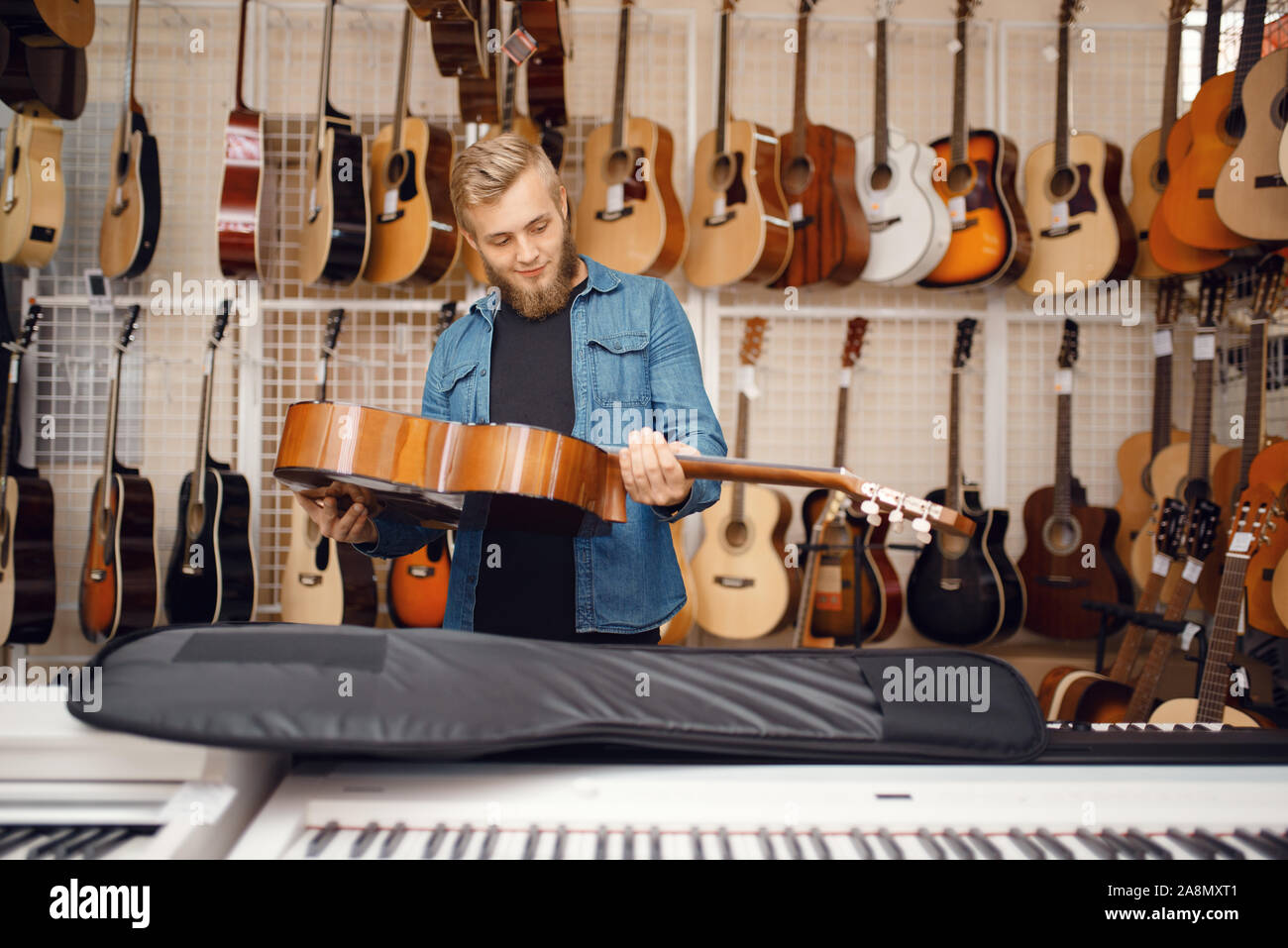 Il chitarrista mette la chitarra nel caso, music store Foto Stock