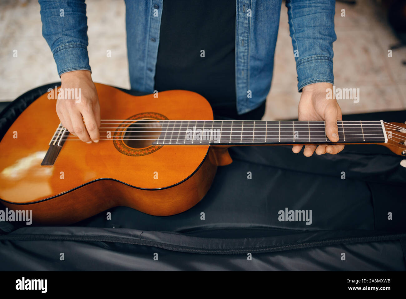 Il chitarrista mette la chitarra nel caso, music store Foto Stock