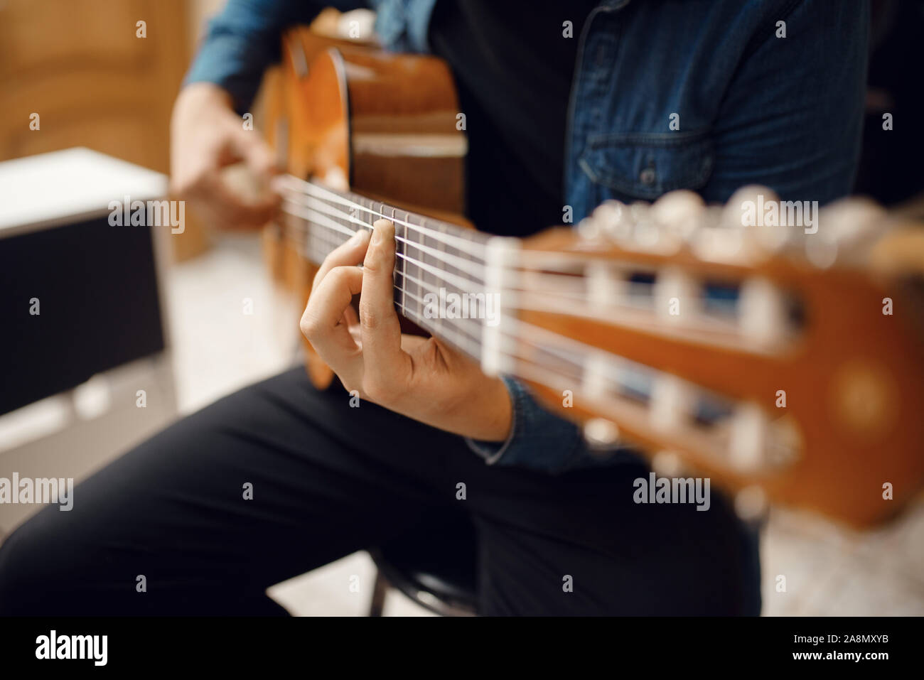 Il chitarrista cercando di riprodurre sulla chitarra in music store Foto Stock