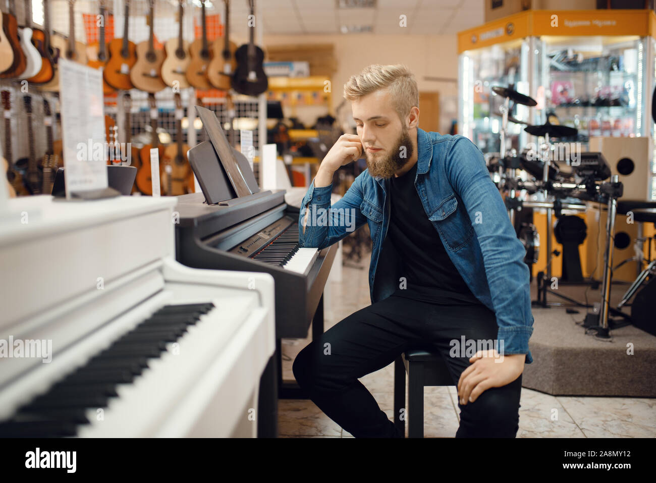 Giovane musicista pone al pianoforte in music store Foto Stock
