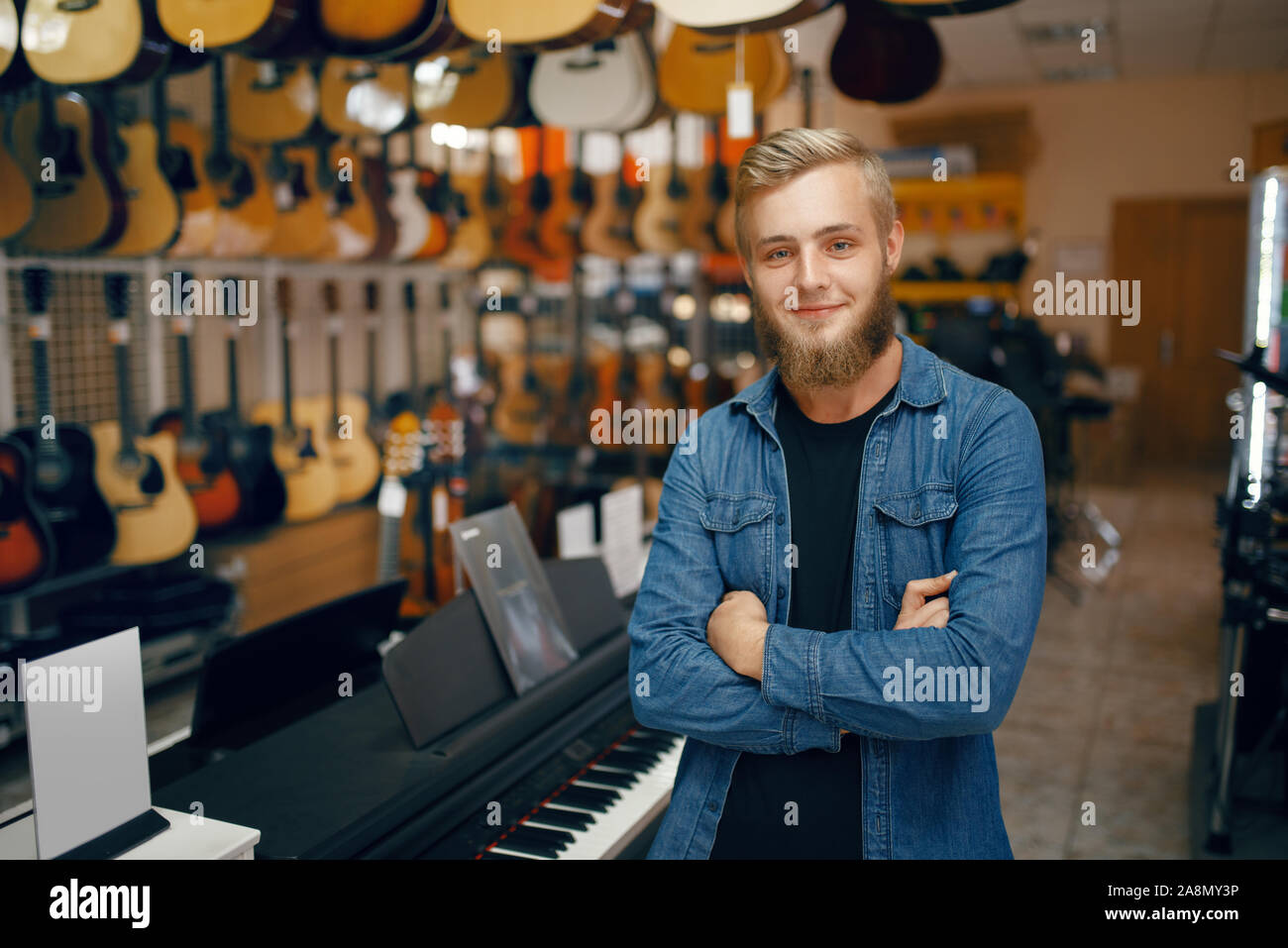 Giovane uomo pone alla vetrina in music store Foto Stock