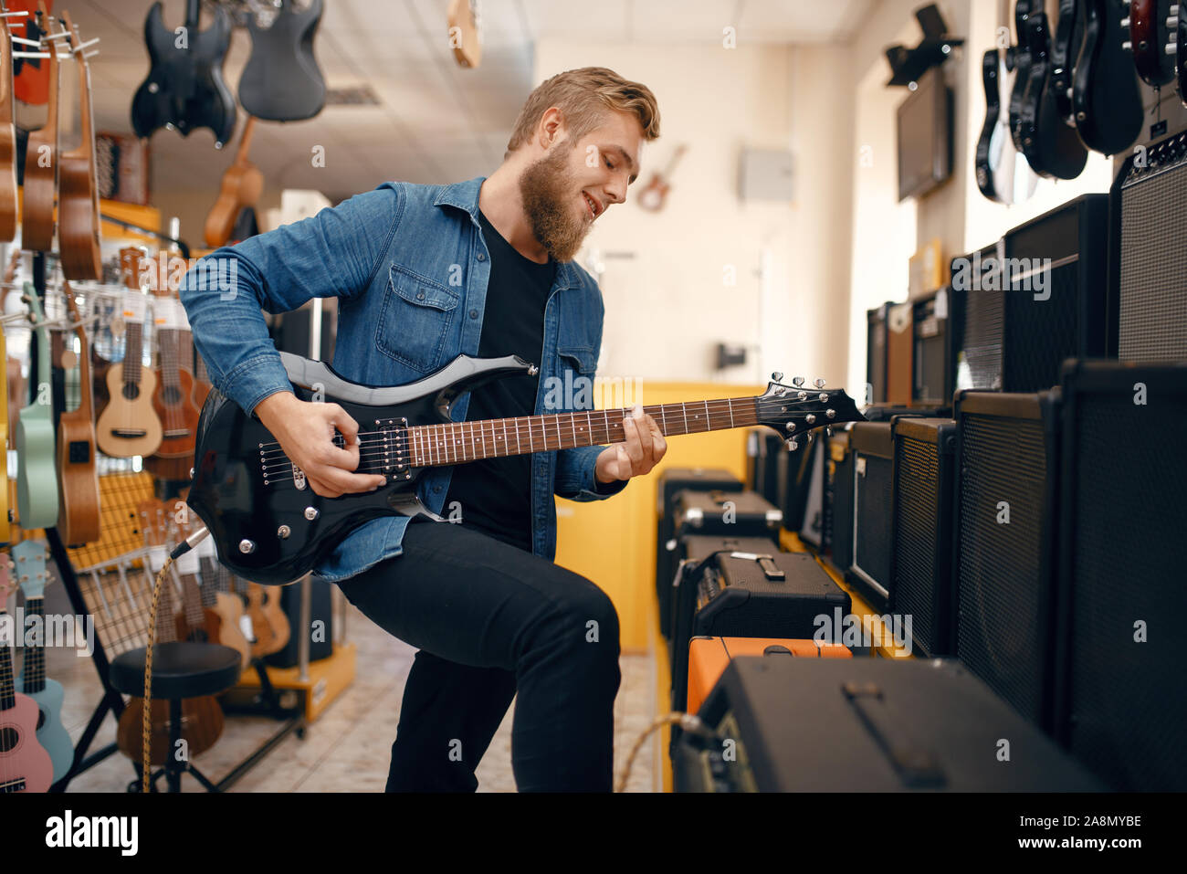 Il chitarrista suona sulla chitarra elettrica in music store Foto Stock