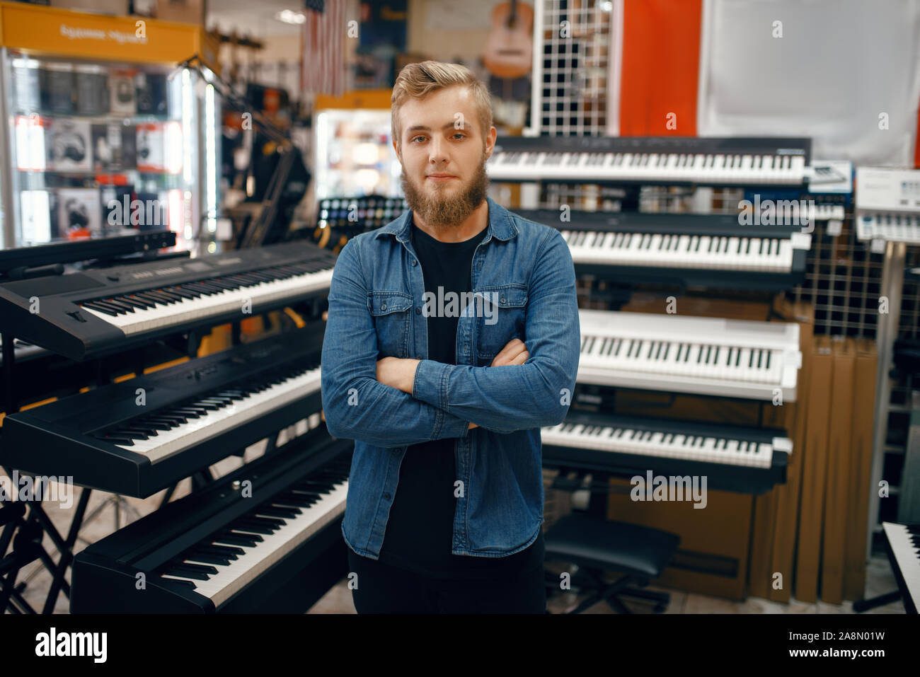 Giovane uomo sintetizzatore scegliendo in music store Foto Stock