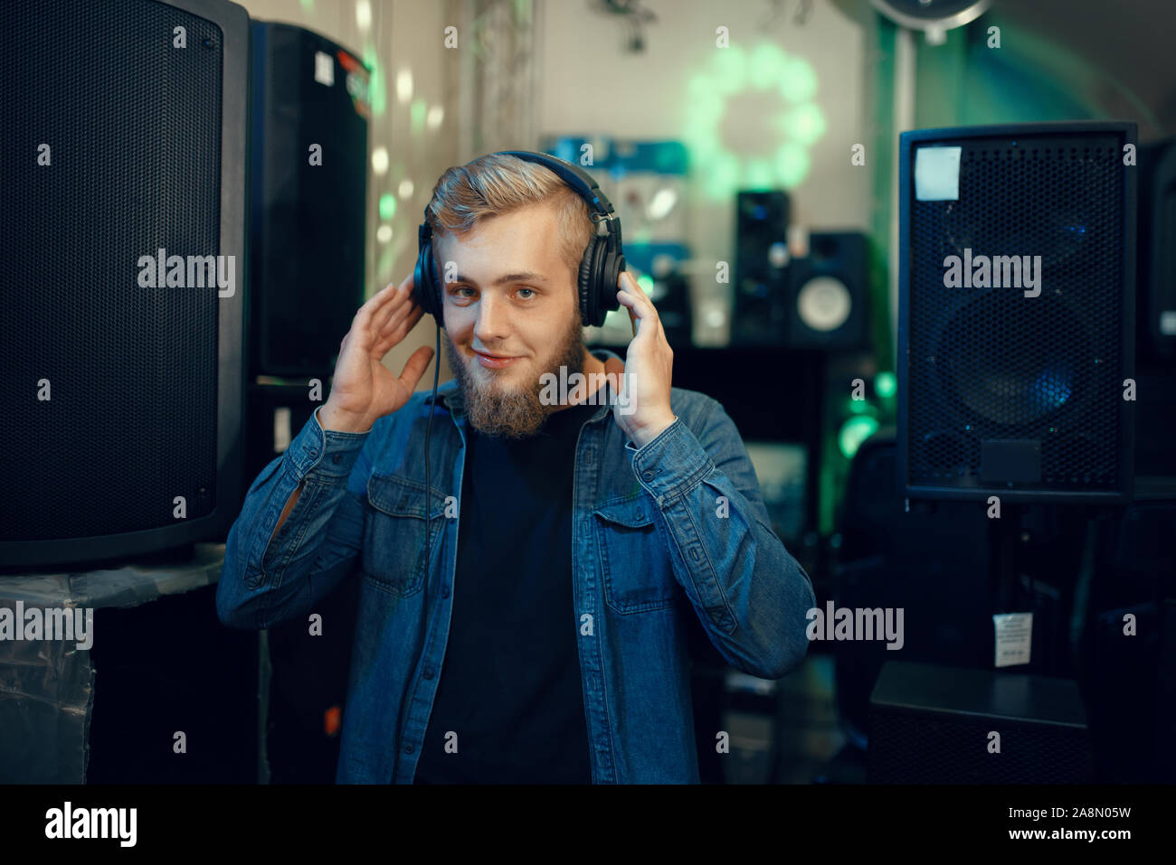 Giovane musicista la scelta di auricolari in music store Foto Stock