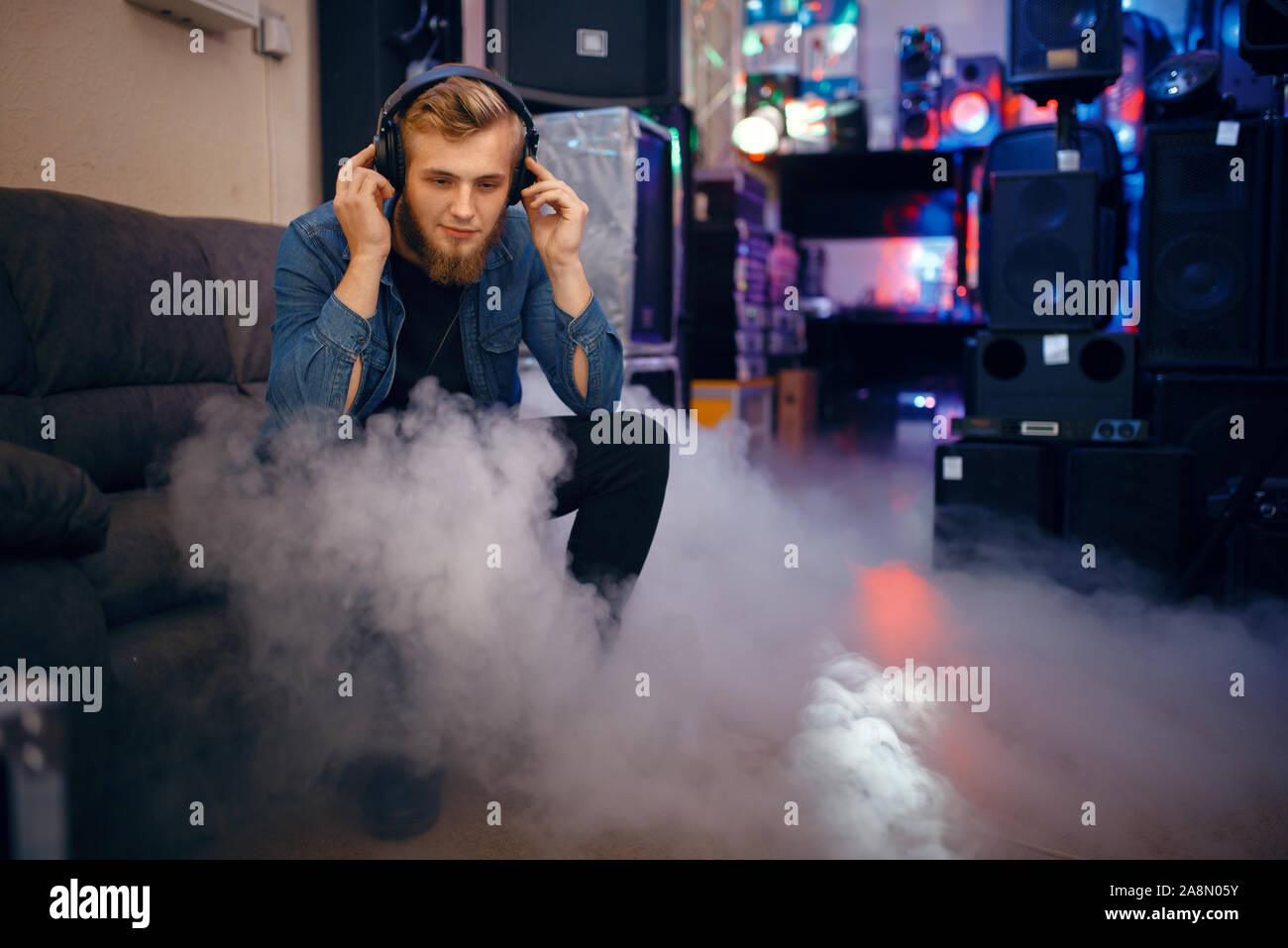 Giovane musicista la scelta di auricolari in music store Foto Stock
