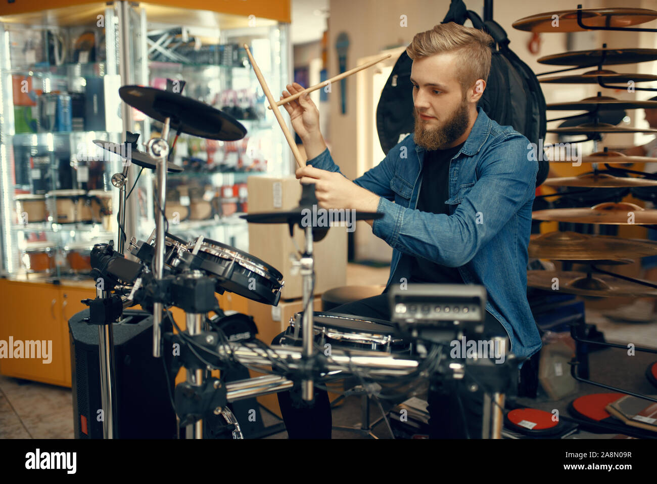 Giovane musicista suona sul tamburo impostata in music store Foto Stock