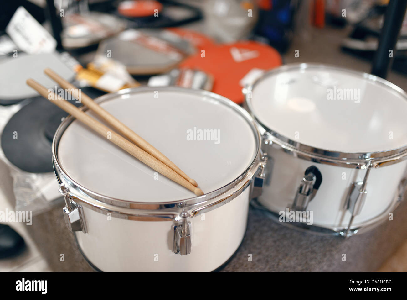 Tamburi e bacchette in vetrina nel negozio di musica Foto Stock
