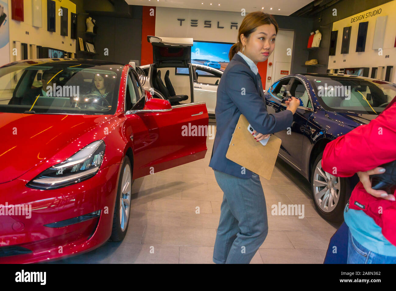 Shanghai, Cina, donna che presenta, Rich Luxury Chinese Electric Car Showroom, marchio Tesla, assistente boutique, giovane donna cinese, capitalismo cinese Foto Stock