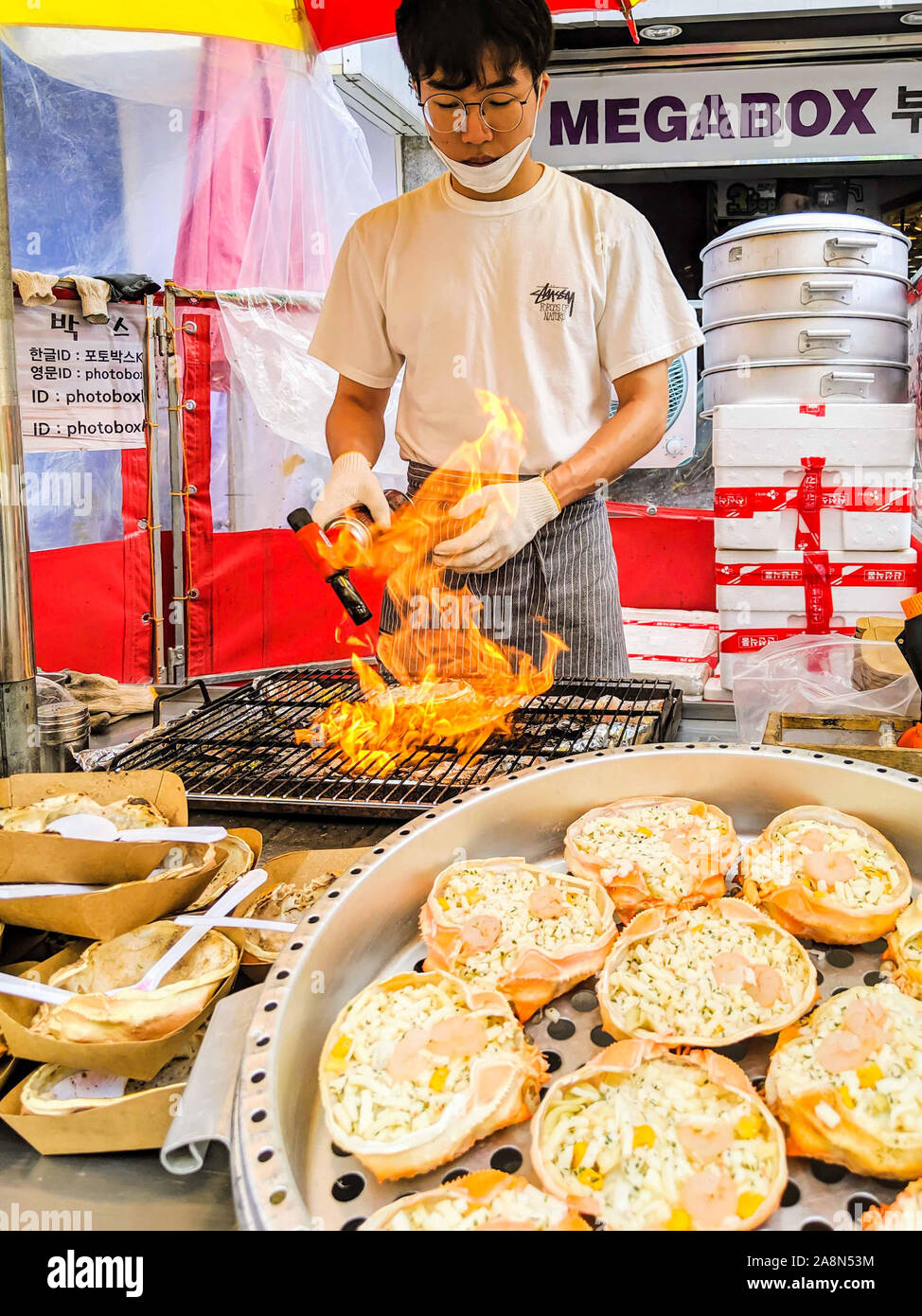Settembre, 13, 2019-BUSAN COREA DEL SUD : uomo asiatico grigliare carne usando una torcia per le strade di Busan in Corea del Sud. Foto Stock
