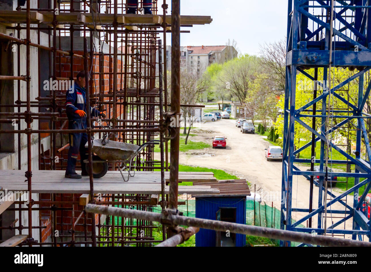 Impalcatura con piattaforma di legno è posizionato contro l edificio, edificio in costruzione. Foto Stock