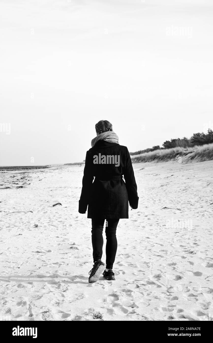 Donne solitarie passeggiate sulla spiaggia Foto Stock