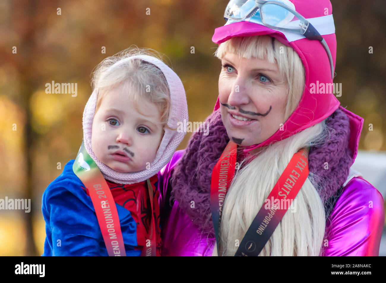 Glasgow, Scotland, Regno Unito. 10 Novembre, 2019. Una madre e un bambino corridori in abiti fantasiosi costumi all'inizio di MoRunning che è una serie di 1.5km, 5km e 10km di piste svolge in 24 sedi in tutto il Regno Unito & Irlanda nel mese di novembre in aiuto della Fondazione Movember che raccogliere fondi per la salute dell'uomo. Questo anno si festeggia il suo decimo anniversario e ha raccolto oltre 1 milione di sterline. Questi eventi sollevano i fondi per i principali problemi di salute di fronte a uomini che sono il cancro della prostata, cancro testicolare, salute mentale e il suicidio. Credito: Berretto Alamy/Live News Foto Stock