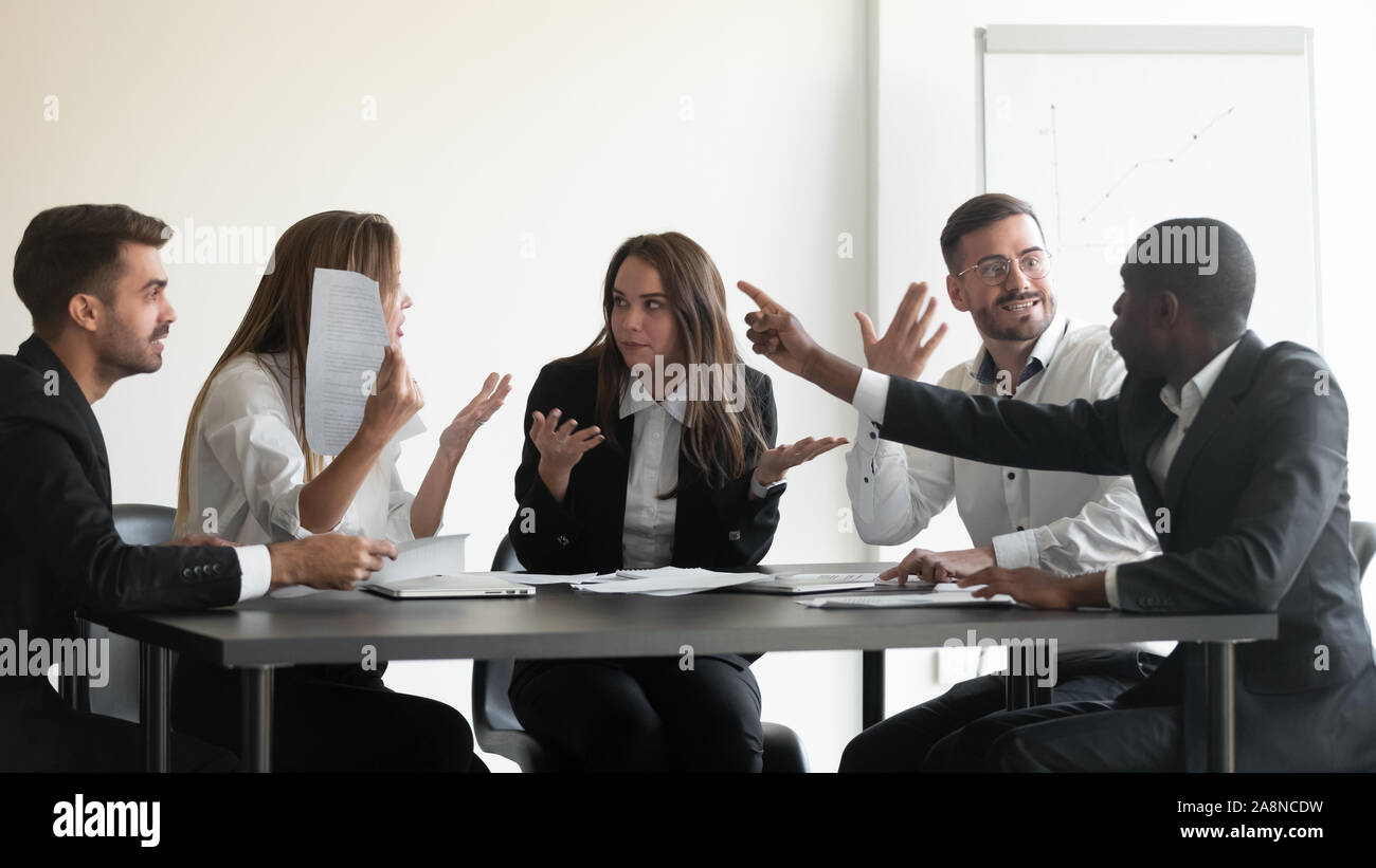 Mad diversi dipendenti controversia a office meeting Foto Stock