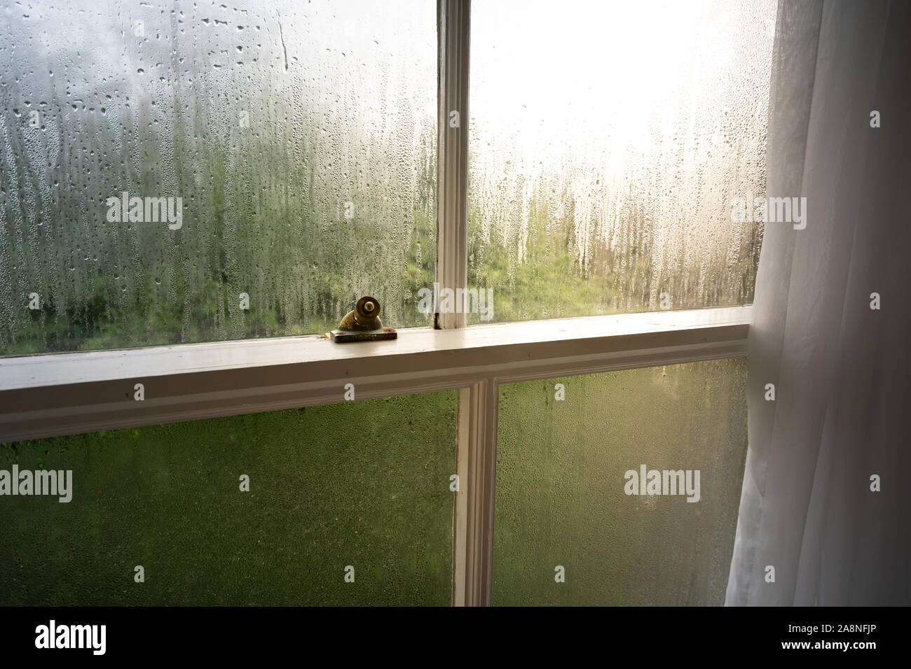 La pioggia coperti finestre a ghigliottina in un grande hotel Vittoriano nel Derbyshire, gocce di pioggia su windows, freddo e fresco all'esterno in inverno, di condensazione Foto Stock