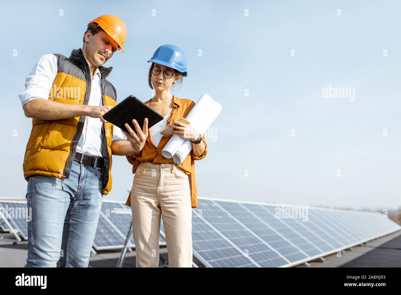 Due ingegneri o architetti esaminando centrale solare con una tavoletta digitale. Stazione solare concetto di sviluppo Foto Stock