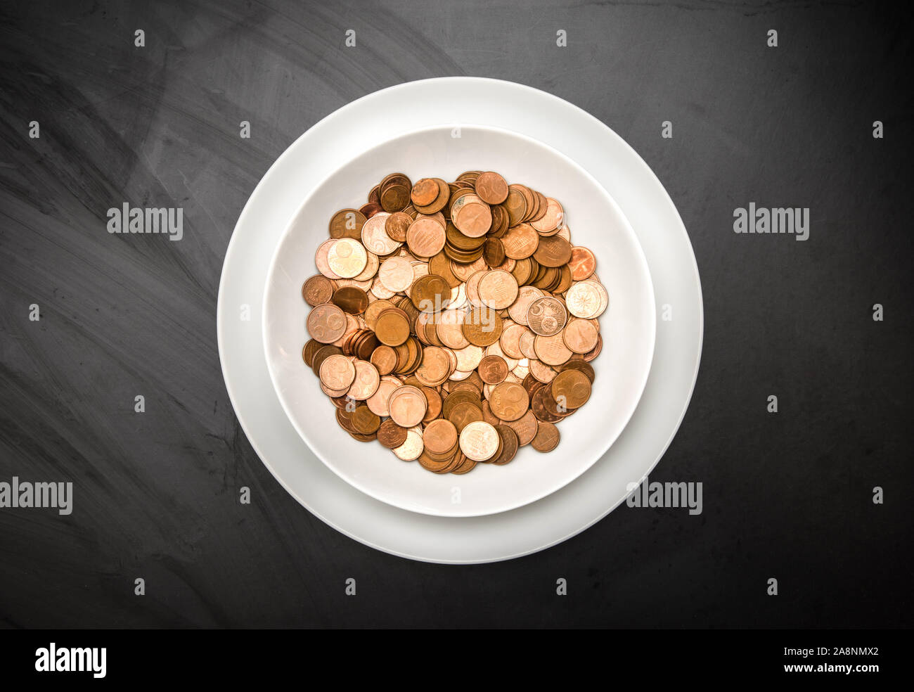 Un sacco di denaro nel piatto su sfondo scuro Foto Stock