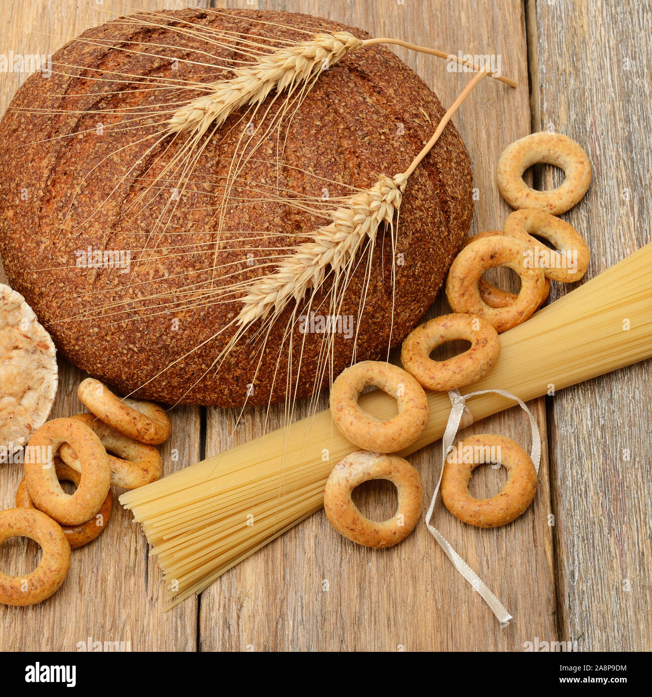Pane, pasta e pasticceria su una superficie in legno Foto Stock