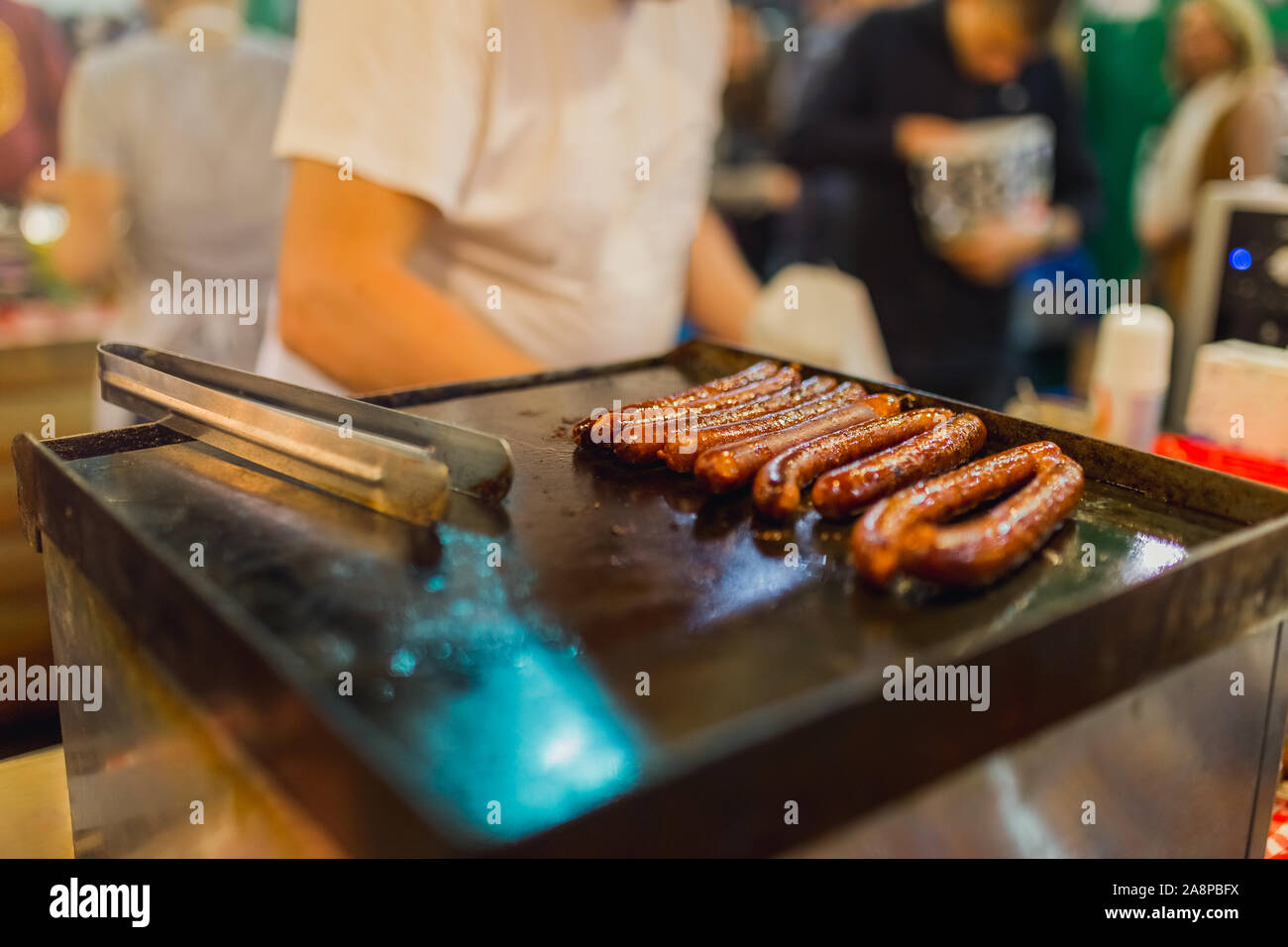 Chiudere l immagine di salsicce cottura su una griglia piana. Street food concept. Foto Stock