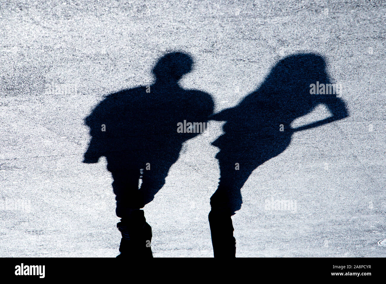 Sfocata ombra silhouette di un uomo e di una donna sulla città strada pedonale in alto contrasto bianco e nero notte Foto Stock