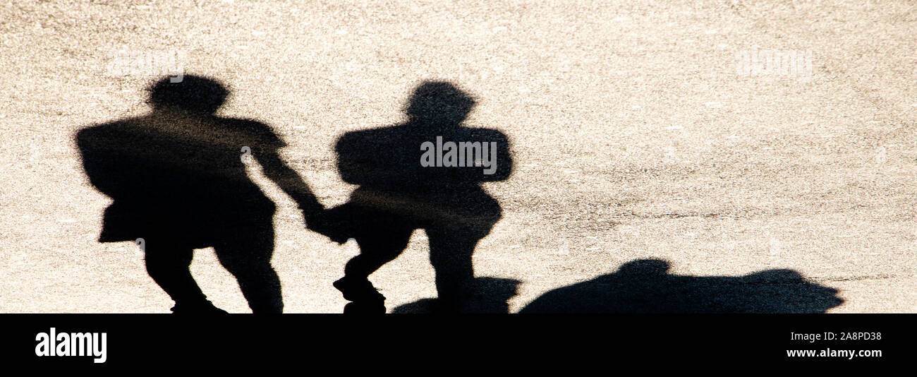 Sfocata ombra silhouette di persone a piedi la città sulla strada pedonale in alto contrasto seppia in bianco e nero Foto Stock