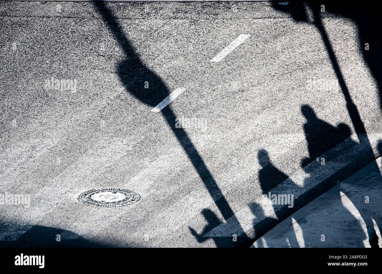 Sfocata ombra silhouette di pedoni in attesa su una strada di città incrocio nella notte, dal di sopra Foto Stock