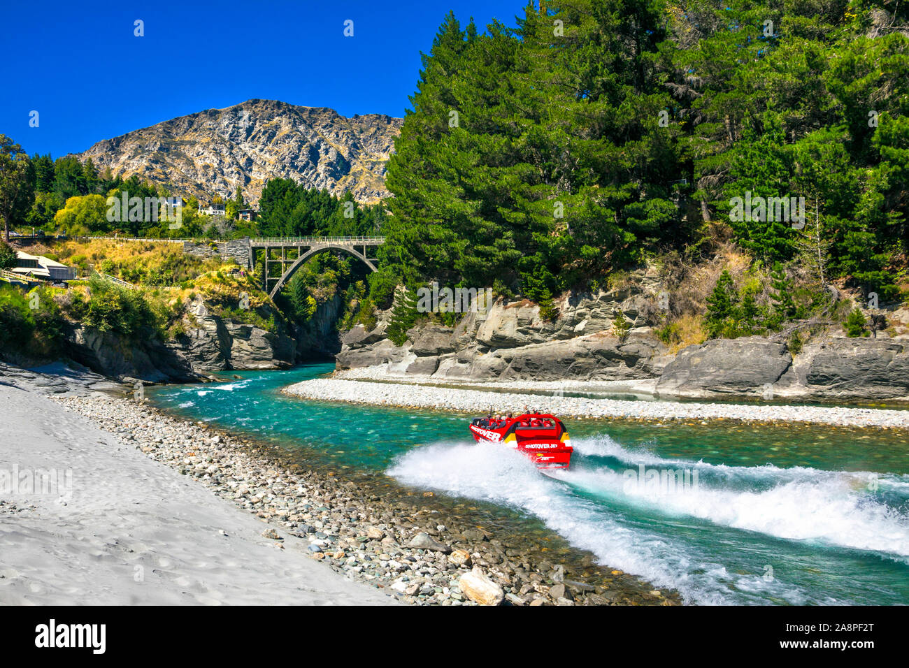 Rosso barca della nervatura di accelerare un fiume Shotover Jet nervatura esperienza in barca vicino a Queenstown, Nuova Zelanda Foto Stock