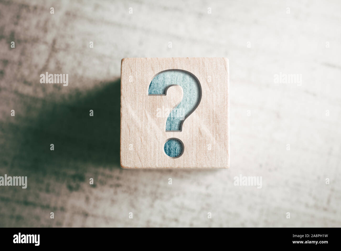 Punto interrogativo sul blocco di legno su un tavolo Foto Stock
